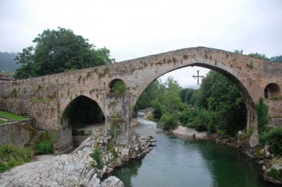 Die &quot;Puente Romano&quot;, die romanische Brücke (12./13.Jh.) in Cangas de Onís, die den Río Sella überspannt.<br />Das herabhängende Kreuz soll an das mythische Kreuz von Pelayos erinnern, das er im Kampf gegen die Mauren trug.