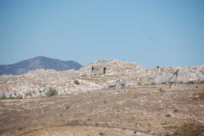 Große Ruine inmitten der Felsen vor der Sierra de la Foradada