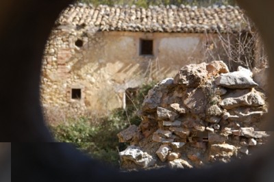 Der Innenhof der Mas de Tetuan, durch ein Mauerloch fotografiert.